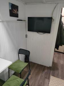 a room with a chair and a television on a wall at Dorćoleta in Belgrade