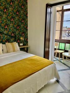 a bedroom with a large painting of flowers on the wall at Apartamentos Makao Puerta del Olivillo in Jerez de la Frontera