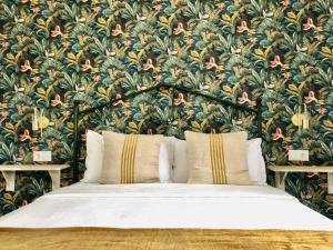 a bedroom with a large bed with a floral wallpaper at Apartamentos Makao Puerta del Olivillo in Jerez de la Frontera