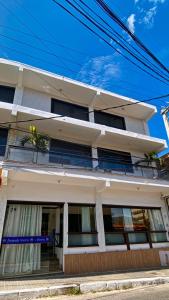 - un bâtiment blanc avec un balcon dans une rue dans l'établissement Pousada Vieira, à Arraial do Cabo