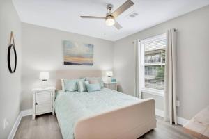 a white bedroom with a bed and a ceiling fan at Short walk or shuttle to wide open public beach! in Santa Rosa Beach +27 photos