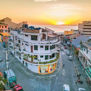 une rue de la ville au coucher du soleil avec un grand bâtiment dans l'établissement Pousada Vieira, à Arraial do Cabo