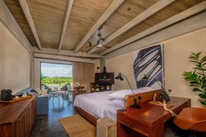 a bedroom with a bed and a desk and a window at Atelier Playa Mujeres- Adults Only - All Inclusive Resort in Cancún