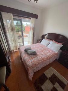 a bedroom with a bed and a large window at Blue Tex in Vila Chã