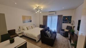 um quarto com uma cama, 2 cadeiras e uma mesa em The Signature Luxury suites CPG em Bawaleshi