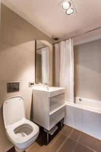 La salle de bains blanche est pourvue de toilettes et d'un lavabo. dans l'établissement Anvers Apartament, à Bucarest