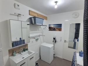 La salle de bains blanche est pourvue de toilettes et d'un lavabo. dans l'établissement Au cœur d'Agroparc, à Avignon