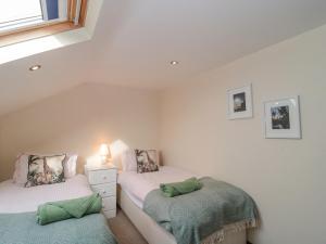 a bedroom with two twin beds and a window at The Linhay in Bridport