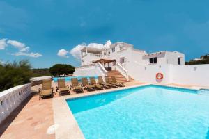 a villa with a swimming pool in front of a house at Es Macar, warm pool in Es Canutells