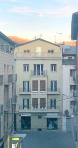 ein hohes weißes Gebäude mit einem Balkon in einer Stadt in der Unterkunft Cal Sisquet - TON in La Seu d'Urgell