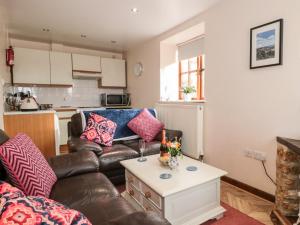 een woonkamer met een bank en een tafel bij Barton Cottage in Bridport