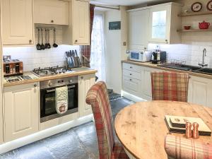 a kitchen with a wooden table and a wooden tableablish at Betsy Cottage in Windermere