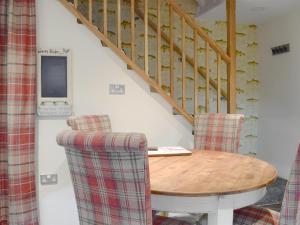 a table and chairs in a room with a staircase at Betsy Cottage in Windermere