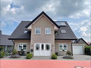 a brown brick house with a white garage at Privatzimmer Steinmetz in Reken in Reken