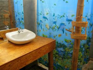 a bathroom with a sink and a fish mural at Camping Matufa Mancora in Canoas De Punta Sal