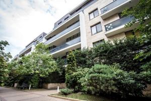 um prédio de apartamentos com árvores em frente em Anvers Apartament em Bucareste