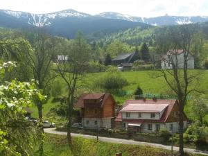 una casa en un pueblo con montañas en el fondo en Wysokie Bale Kwatery Jagniatków, en Jelenia Góra