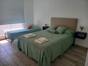 1 dormitorio con 2 camas y toallas. en EnSueños Tandil en Tandil