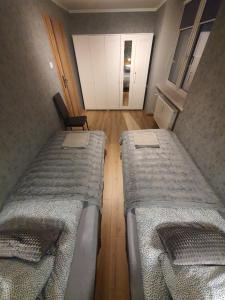 pokój z 2 łóżkami i krzesłem w obiekcie JDK Apartamenty Młynarska 44m2 6-osobowy w Kaliszu