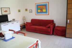 salon z czerwoną kanapą i stołem w obiekcie CASA VACANZE DA RIKI w mieście Peschiera del Garda