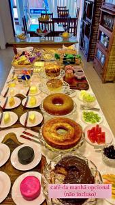 une table avec de nombreuses assiettes de nourriture dans l'établissement Pousada Vieira, à Arraial do Cabo