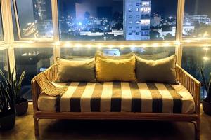 un banco con almohadas en una habitación con ventana en -Depto *ANGRA* en Tandil, BA- en Tandil