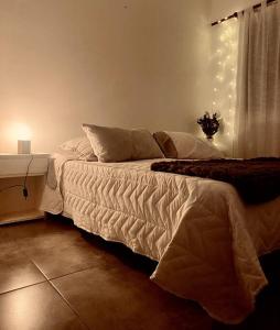 1 dormitorio con cama y mesa con luces en -Depto *ANGRA* en Tandil, BA- en Tandil