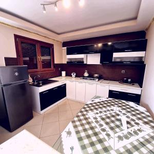 a kitchen with a black refrigerator and white cabinets at GUEST HOUSE in VERGIA in Vergia