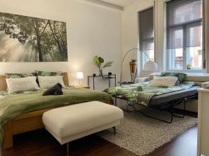 a bedroom with two beds and a ottoman at St3 Apartman Szeged in Szeged