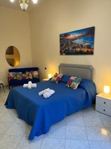 um quarto com uma cama azul com toalhas em Dimora San Ferdinando em Nápoles