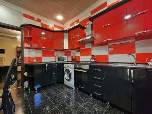 a red and white kitchen with a washing machine at Villa in Chakvi in Chakvi
