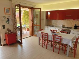 una cucina con tavolo e sedie e una cucina con porta di CASA VACANZE DA RIKI a Peschiera del Garda