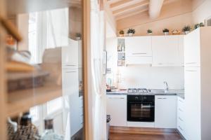 une cuisine avec des armoires blanches et une cuisinière dans l'établissement Ginevra Suite, à Cortone 20 autres photos