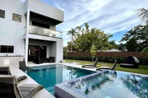 a swimming pool in front of a house at The Elements Luxury Home Fort Lauderdale in Fort Lauderdale