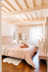 ein großes Schlafzimmer mit einem großen Bett und einem Tisch in der Unterkunft Ginevra Suite in Cortona