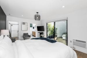 - une chambre blanche avec un grand lit et une fenêtre dans l'établissement Modern Guest Room, à Los Angeles