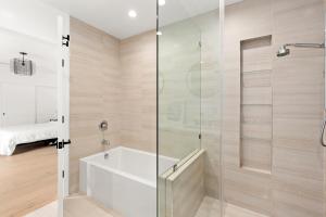 La salle de bains est pourvue d'une baignoire et d'une douche en verre. dans l'établissement Modern Guest Room, à Los Angeles