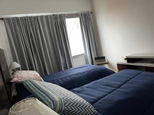 Un dormitorio con una cama azul y una ventana en Hermoso Apartamento en Caballito a 200mts del metro en Buenos Aires