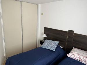 1 dormitorio con cama azul y almohada en Hermoso Apartamento en Caballito a 200mts del metro en Buenos Aires