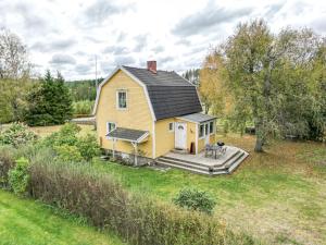 a yellow house with a deck in a yard at The Solhem Cabin in Strömstad