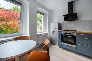 a kitchen with a white table and a window at Blick Apartments - Waterfront Green Apartment in Zgorzelec