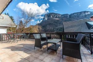 a balcony with chairs and tables and a view of mountains at Holiday Chalet near Bled 