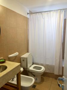 y baño con aseo blanco y lavamanos. en ALOHA Güemes Premium, 1 dorm Clásico y Moderno en Córdoba