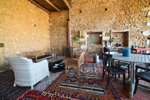 La Mothe-Saint-Héray的住宿－Mas des Gourmands，配有桌椅和石墙的房间