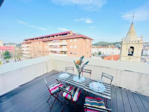 a table and chairs on top of a balcony at Sweet Apartments Downtown in Vila Nova de Famalicão