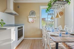 a kitchen with a wooden table and a dining room at The Solhem Cabin in Strömstad