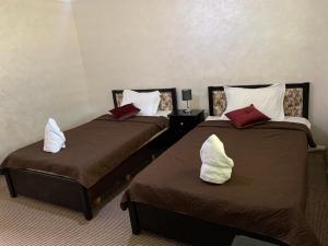 2 łóżka w pokoju hotelowym z poduszkami w obiekcie Paradise Tree w mieście Wadi Musa