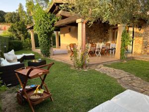 Un patio con una mesa y sillas y una casa. en Villa Dante, en Castiadas