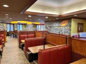a fast food restaurant with wooden tables and chairs at Howard Johnson Plaza by Wyndham by the Falls Niagara Falls in Niagara Falls