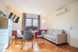 een woonkamer met een bank en een tafel en stoelen bij Apartamento 2 en la muralla romana junto a la Catedral in Tarragona